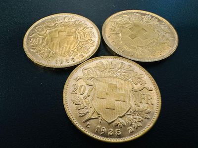 three gold coins sitting on top of each other on a table