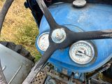 un volant et des jauges sur un vieux tracteur bleu