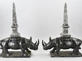two statues of rhinos with a sword on top of them