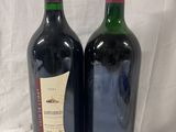 two bottles of wine sitting next to each other on a table