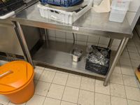 Table en inox à dosseret avec plateau d'entrejambes