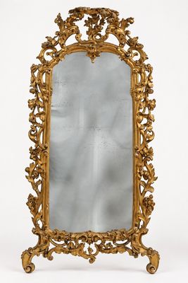un miroir richement sculpté, doté d'un cadre doré et posé sur un socle