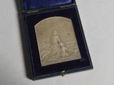 une petite plaque en argent dans un écrin bleu