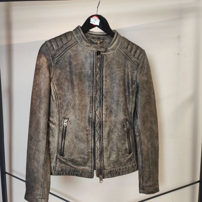 une veste en cuir suspendue à un portant dans un magasin de vêtements