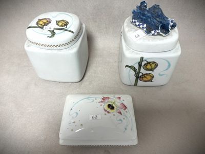 trois récipients en céramique ornés de fleurs, posés sur une table