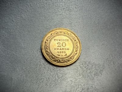 a close up of a gold coin on a gray surface