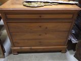 une commode en bois dans une pièce où se trouvent de nombreux autres objets