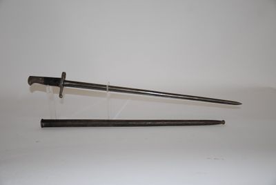 an old sword with a wooden handle sitting on top of a white surface