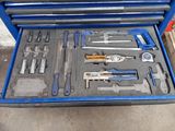 une boîte à outils bleue avec des outils sur le sol