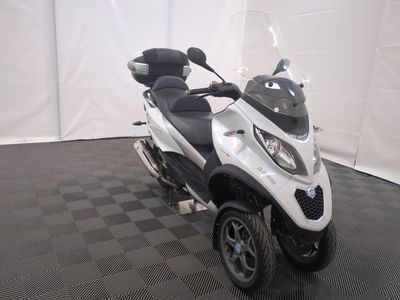 a white and black scooter parked on a black and white checkered floor