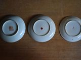 three white plates sitting on top of a wooden table next to each other