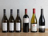 plusieurs bouteilles de vin sont alignées sur une table en bois