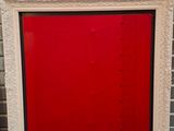 un vieux cadre photo avec une porte rouge devant un mur de briques