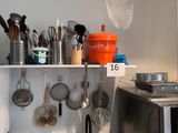 une étagère avec des casseroles et des poêles dans une cuisine