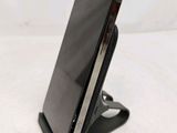 a close up of a cell phone on a stand on a white surface