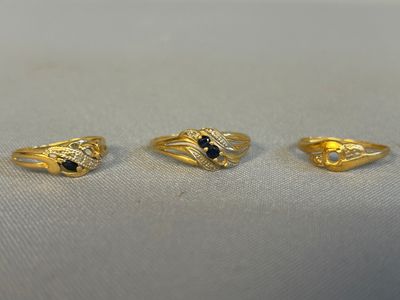 trois bagues en or ornées de pierres noires et de diamants