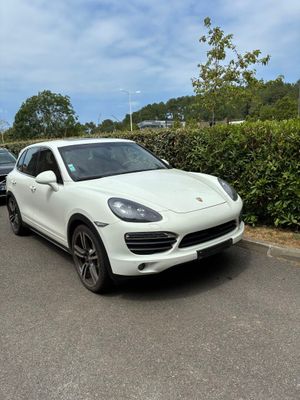 a white porsche cayen parked on the side of the road