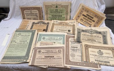plusieurs vieux certificats en papier posés sur un drap blanc
