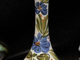 a small vase with a name on it next to two other vases