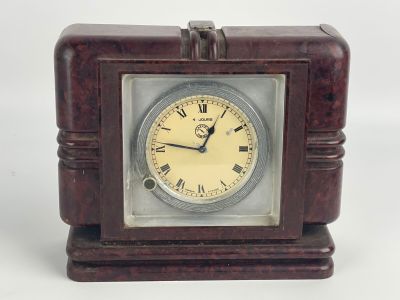 une petite horloge en bois avec des chiffres romains