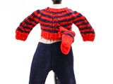 une poupée tricotée portant un pull rouge et bleu et des mitaines