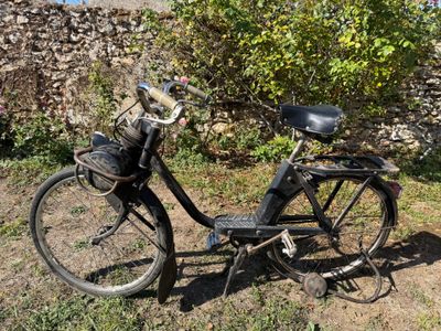 un vélo garé dans l'herbe près d'un mur de pierre