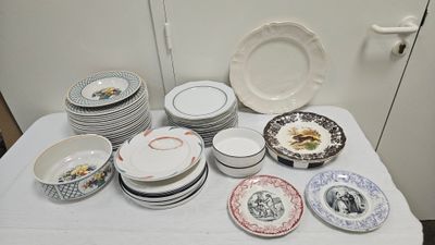 many plates and bowls on a table with a white table cloth