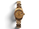 une montre Rolex pour femme, avec un cadran en or et des index en diamant