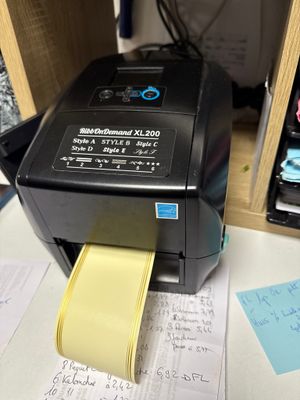 a printer sitting on top of a desk with a yellow paper