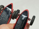a person holding a pair of toy cars that have wheels on them