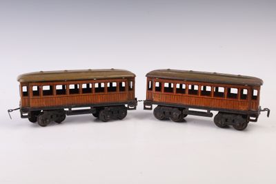 une paire de wagons de train miniature posés sur une surface blanche, avec un fond blanc