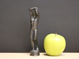 a statue of a man standing next to an apple