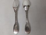two spoons and a fork on a table