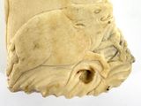 a carved object with a bird on it on a white surface