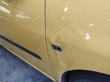 a close up of a yellow car with a black door handle