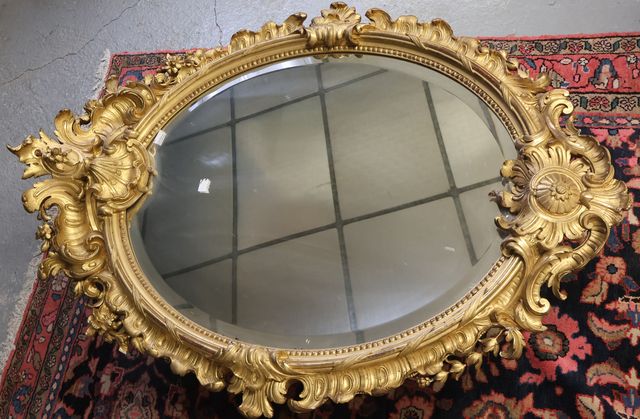 Important miroir ovale cadre doré en bois et stuc, de style rocai...