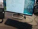 un bureau sur lequel se trouvent un ordinateur, un clavier, une souris et d'autres objets