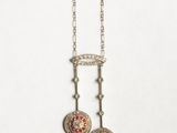a close up of a pair of necklaces on a white surface