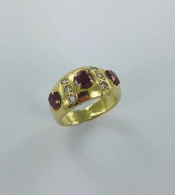 gros plan d'une bague en or avec une pierre rouge