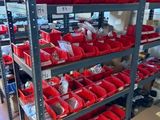 many red bins on the shelves in the warehouse