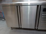 a stainless steel refrigerator in the middle of a kitchen