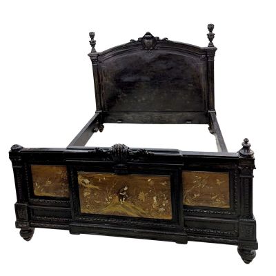 a black bed with gold decorations on the headboard