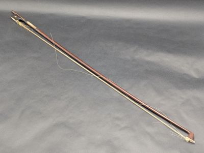 a close up of a wooden stick with a needle on a gray surface