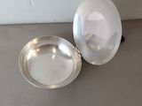 a silver plate and a silver bowl sitting on a table