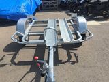 a trailer with a motorcycle attached to it in a parking lot