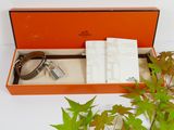 an orange box with a watch and a book in it