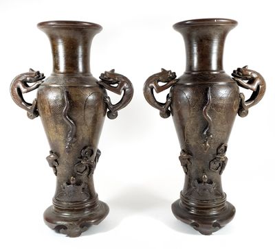 two vases that are sitting side by side on a white surface