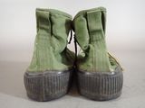 pair of green boots with black soles on a white surface