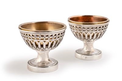 paire de coupes à pied en argent et en or, posées sur des socles, sur fond blanc