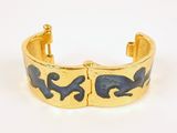a close up of a gold cuff with blue enamel on it